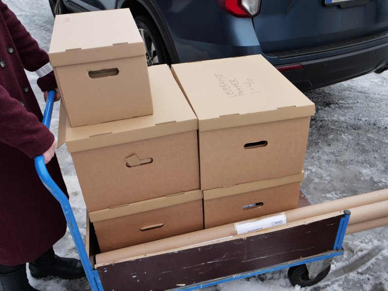 Fem pappesker plassert på en tralle.