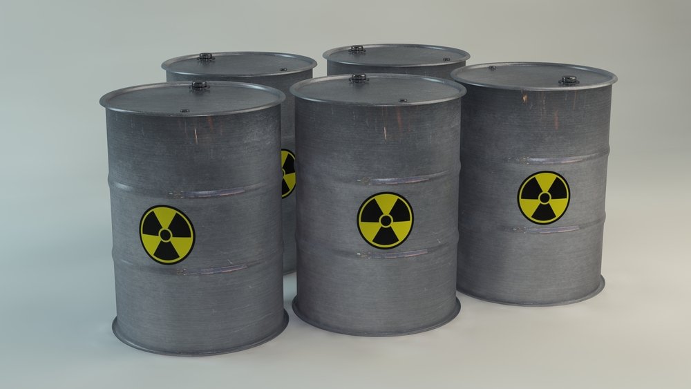 Fem grå metalltønner med gult og svart strålepropell-symbol på.